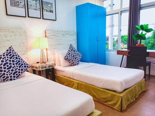 a room with two beds and a blue cabinet at The Mansion Boutique Hotel in Mabalacat