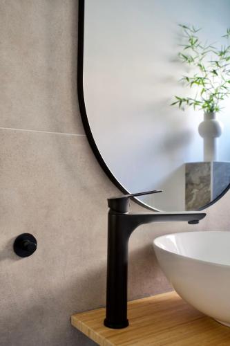 a mirror on a stand next to a sink at LavandinaLuxe APP in Novi Vinodolski