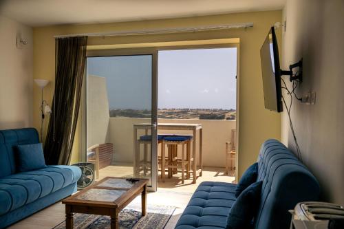 a living room with a blue couch and a table at Elegant Apartments with Open Views in Xagħra
