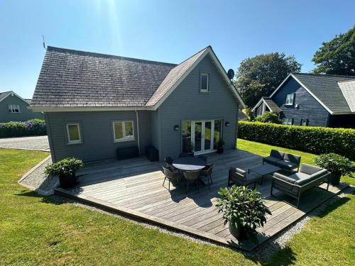 a deck in the backyard of a house at Trewhiddle Retreat V14 by Together Travel - Luxury 4-Bedroom Villa in St Austell