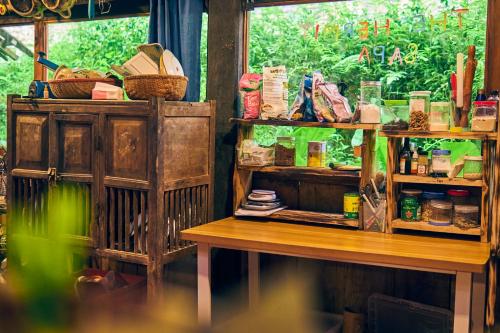a room with a table and a shelf with products at The Hermit Sapa Homestay in Sa Pả