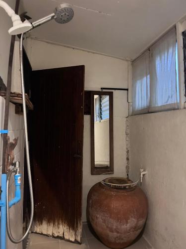 a bathroom with a large vase and a shower at Chest's Place in Bangkok