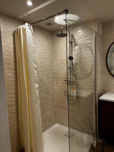 une douche avec une porte vitrée dans une salle de bain dans l'établissement Suite cap d Agde, au Cap d'Agde