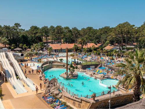 un parc d'attractions avec une grande piscine et des toboggans dans l'établissement Camping Village Le Vieux Port*****, à Messanges