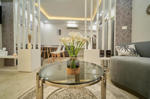 a living room with a vase of flowers on a glass table at prestige pyramids INN in Cairo