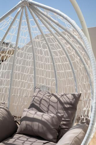 a white swing with pillows on a couch at Sunlit Stylish Penthouse with Hot Tub - Close to Sliema Promenade, St Julian's & St Georges Bay in Il-Gżira