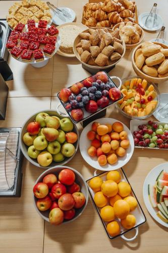 a table with many plates of fruits and pastries at Art Hotel Tartini in Piran