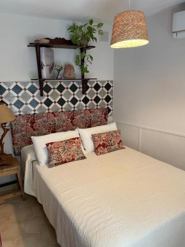 a bedroom with a bed with pillows on it at Apartamento en Casa Patio "Pan y Conejo" in Córdoba