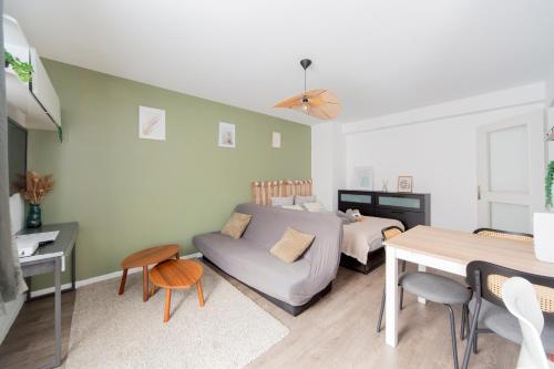 a bedroom with a bed and a couch and a table at Art de recevoir - L'Écrin de Margnolles - Croix Rousse - Métro C-Cuire in Caluire-et-Cuire