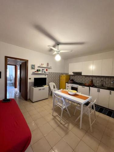 a kitchen with a table and chairs in a room at San Giorgio (Me) Comodo appartamento a 100 metri dal mare in elegante residence, 4/5 posti letto, parcheggio privato. in San Giorgio