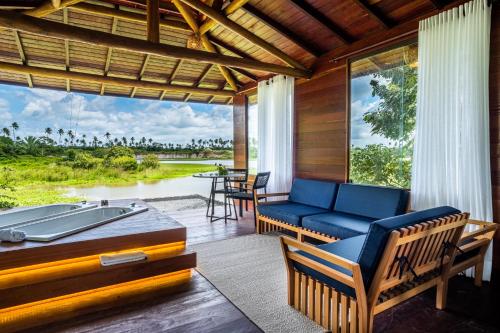 a screened in porch with a couch and a table at Eco Luar Boutique Hotel in Igarassu