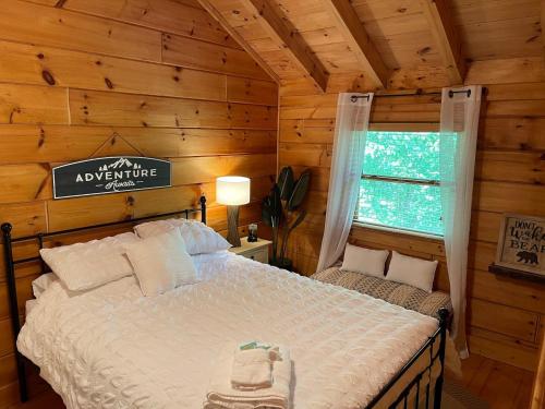 una camera con un letto in una baita di tronchi di Two Bears Cabin a Blue Ridge