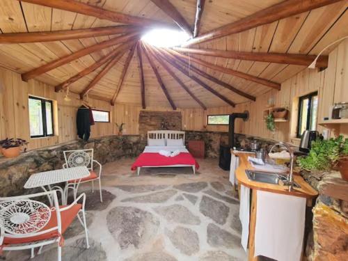 a room with a bed in the middle of a building at Eco Roundhouse Quinta Carapeto in São Luis