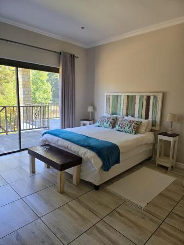 a bedroom with a large bed and a balcony at Mountain Villa 238 in Clarens