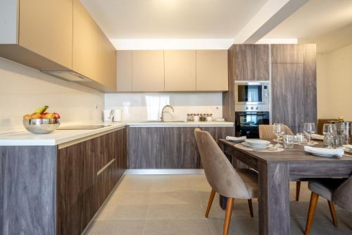 a kitchen with a wooden table with chairs and a dining room at Bright and Modern 2 Bedroom Apartment in Is-Swieqi