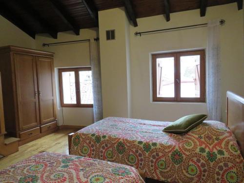 a bedroom with two beds and two windows at Casa da Ponte Bragança in Bragança