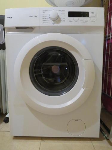 a white washing machine with its door open at Casa da Ponte Bragança in Bragança