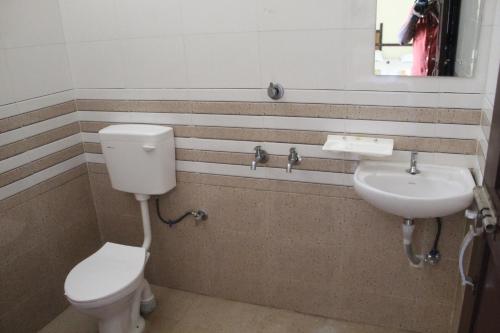 a bathroom with a toilet and a sink at Anna Hotel in Trivandrum