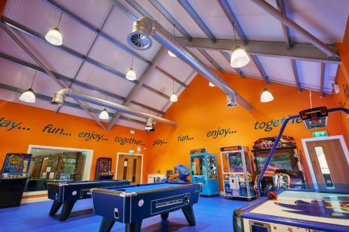a room with ping pong tables and arcade machines at Lakewood Lodge in Saint Fillans