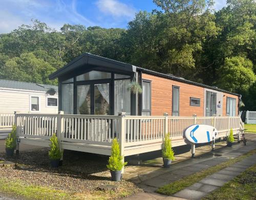 a tiny house with a black roof on a porch at Lakewood Lodge in Saint Fillans