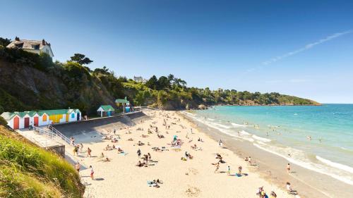 un groupe de personnes sur une plage près de l'océan dans l'établissement Location Suite de L'Olivier, à Plourhan