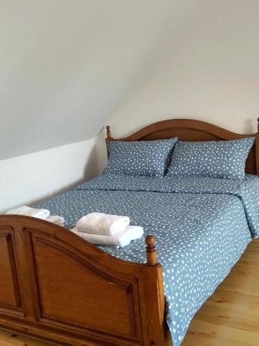 a bed with blue sheets and pillows on it at Tamiški Mir in Staji°evo
