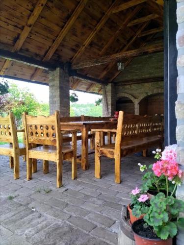 a patio with two benches and a table and flowers at Tamiški Mir in Staji°evo