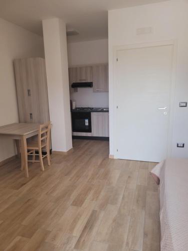 an empty living room with a table and a kitchen at HOUSE AIRPORT Catania in Catania