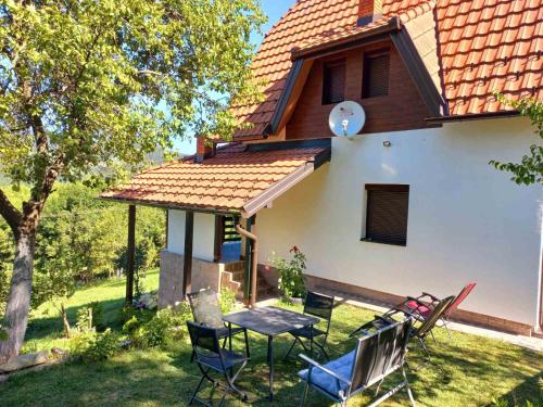 a table and chairs in front of a house at TARA Vila Rajak in Zaovine