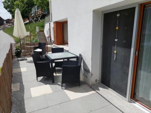a patio with a table and chairs and an umbrella at Ferienhof PUA in Sent