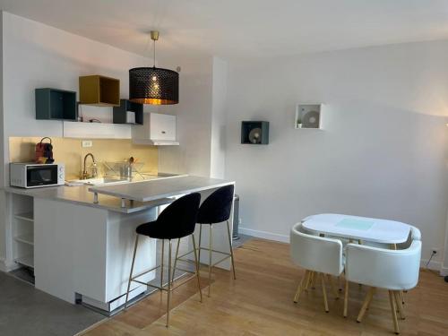 une cuisine avec un comptoir avec des tabourets et une table dans l'établissement Studio moderne et lumineux, proche Tete d Or, Lyon, à Lyon