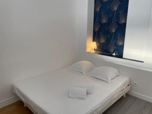 - un lit blanc avec 2 oreillers dans l'établissement Studio moderne et lumineux, proche Tete d Or, Lyon, à Lyon