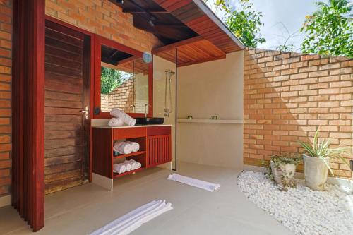 a bathroom with a shower in a brick wall at Eco Luar Boutique Hotel in Igarassu