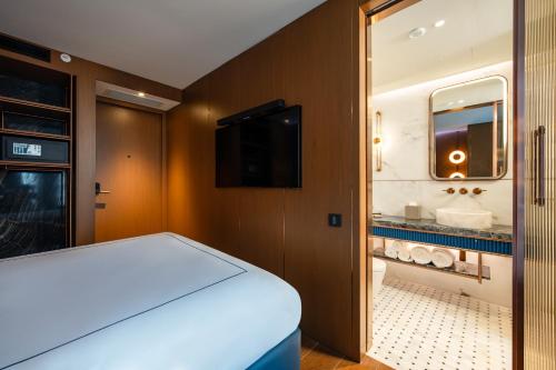 a room with a bed and a mirror and a bathroom at Sura Concept Hotel in Istanbul
