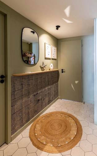 une salle de bain avec un miroir et un tapis rond dans l'établissement Wabi by PRIM0 C0NClERGERIE, à Chamalières