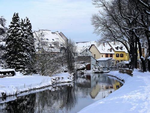 a snow covered city with a river and houses at ibis Styles Strasbourg Nord Palais des Congrès in Schiltigheim