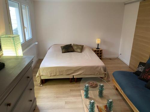 une chambre avec un lit et une table en verre dans l'établissement 2 pièces de plain-pied avec parking et jardin au calme, à Antony