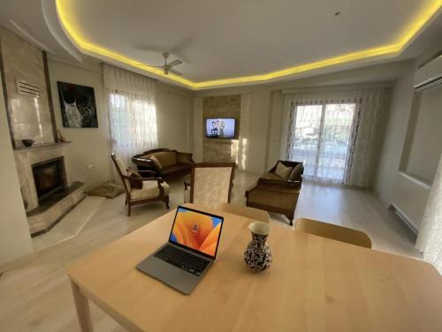 a living room with a table with a laptop on it at Comfortable villa with garden in “Urla İskele” in Urla