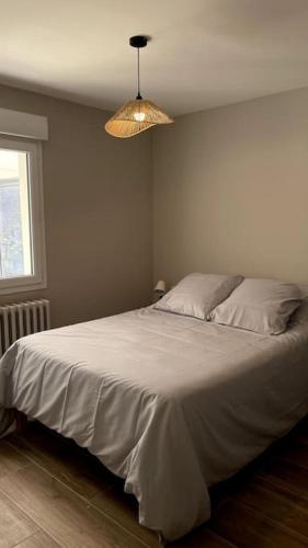 - une chambre avec un grand lit blanc et une lumière dans l'établissement Maison Calme & Jardin au Bouscat, à Le Bouscat