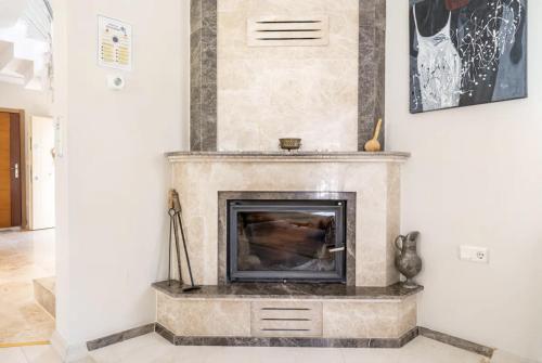 a living room with a stone fireplace in a room at Comfortable villa with garden in “Urla İskele” in Urla