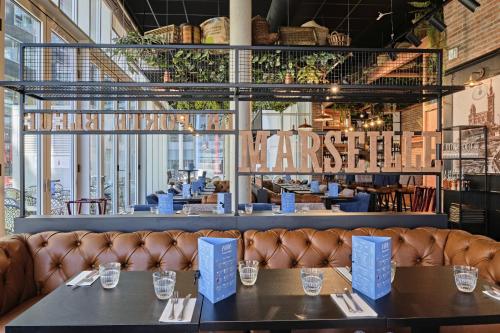 a restaurant with two tables and a leather couch at Appart Hotel Odalys City Marseille Centre Euromed in Marseille