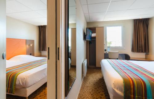 Ένα ή περισσότερα κρεβάτια σε δωμάτιο στο Brit Hotel Le Kerann Nantes St Herblain - Zac De La Lorie