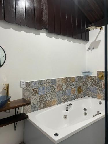 a white bath tub in a kitchen with tiles at Pousada Recanto Pomerano in Pomerode