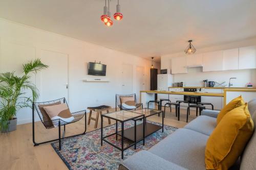 un salon avec un canapé et des chaises et une cuisine dans l'établissement 3 bedroom apartment near CHU and city center, à Lille