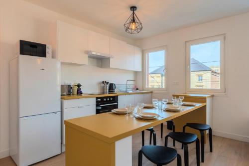 une cuisine avec une table avec des chaises et un réfrigérateur dans l'établissement 3 bedroom apartment near CHU and city center, à Lille