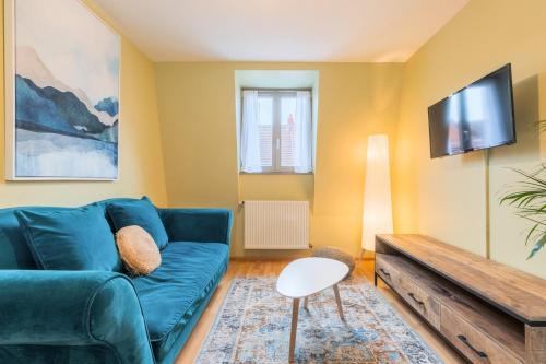 un salon avec un canapé bleu et une télévision dans l'établissement 2 bedroom apartment near metro & shops, à Roubaix