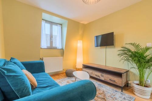 un salon avec un canapé bleu et une télévision dans l'établissement 2 bedroom apartment near metro & shops, à Roubaix