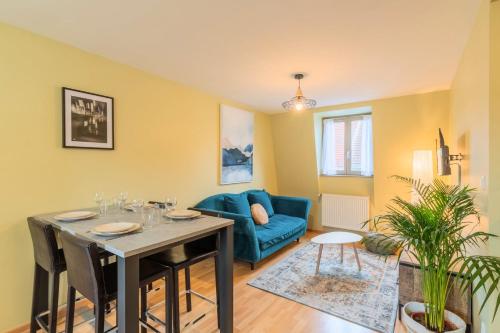 un salon avec une table et un canapé bleu dans l'établissement 2 bedroom apartment near metro & shops, à Roubaix