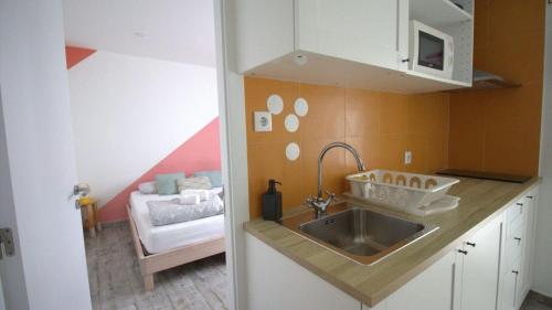 a small kitchen with a sink and a room at WOT Peniche Social in Peniche