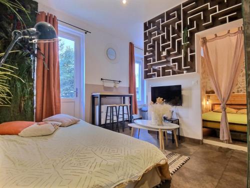 une chambre avec un lit, une table et une télévision dans l'établissement Le Creuset Lyonnais, BNBConciergerie, à Lyon